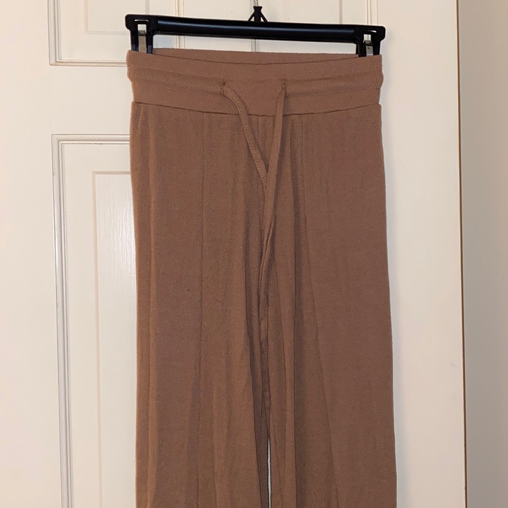 Tan flare pants with a slit on the lower half of pant leg.